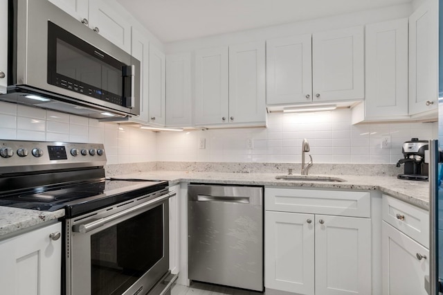 kitchen featuring white cabinetry, appliances with stainless steel finishes, tasteful backsplash, and sink