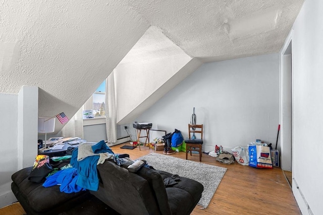 additional living space featuring vaulted ceiling, a textured ceiling, and wood finished floors