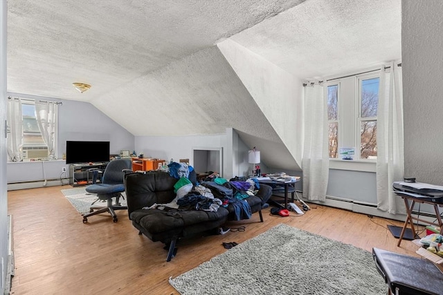 interior space with vaulted ceiling, light wood finished floors, baseboard heating, and a textured ceiling