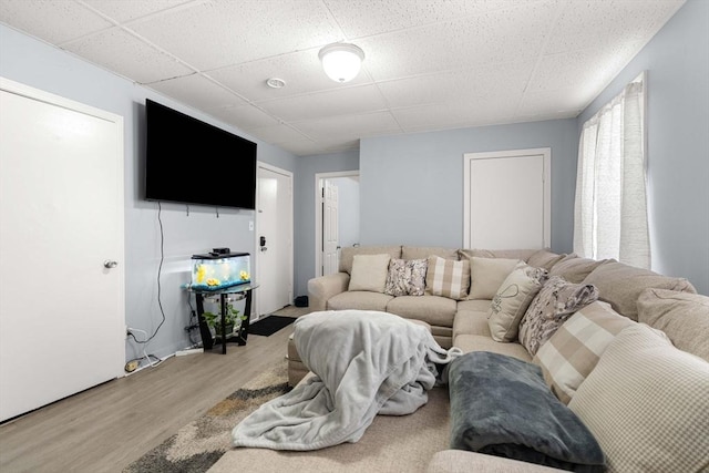 living room with light wood-type flooring and a drop ceiling