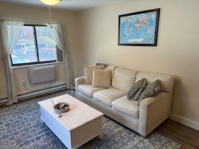 living area featuring baseboard heating, dark wood-style flooring, baseboards, and a wall mounted AC