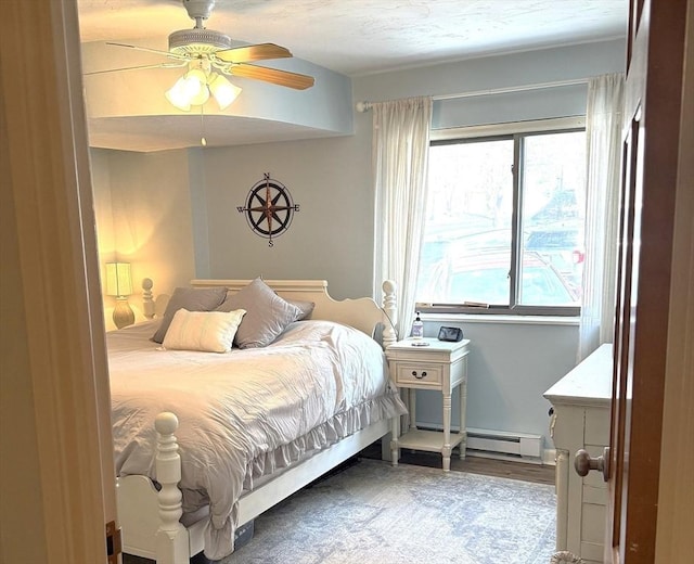 bedroom featuring a baseboard heating unit and ceiling fan