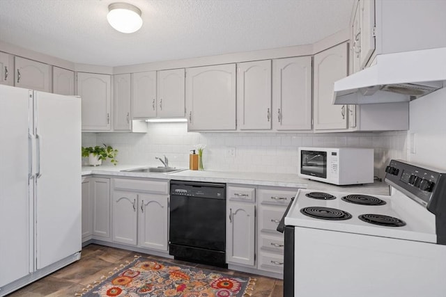 kitchen featuring a sink, light countertops, under cabinet range hood, and white appliances