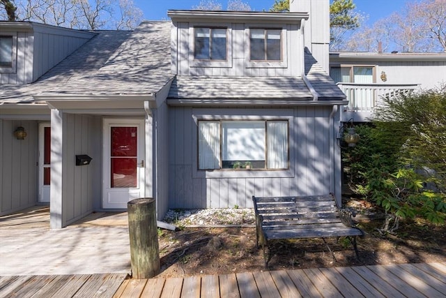 exterior space featuring roof with shingles and a deck