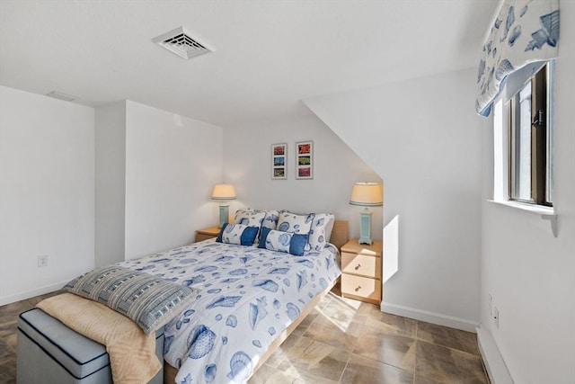 bedroom featuring baseboards and visible vents