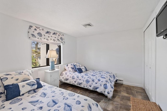 bedroom featuring a baseboard radiator, a closet, and visible vents