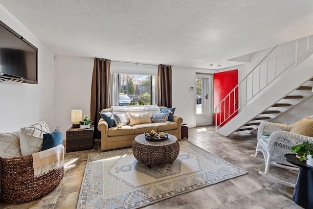 living room with a textured ceiling and stairway