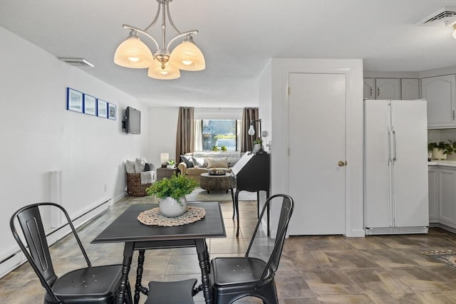 dining room featuring a baseboard heating unit, a notable chandelier, and visible vents