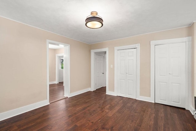 448 Washington St, Warren, MA 01083 - unfurnished bedroom featuring dark wood-type flooring, ornamental molding, and multiple closets