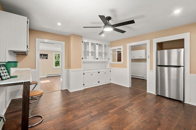 448 Washington St, Warren, MA 01083 - kitchen featuring freestanding refrigerator, a baseboard radiator, ceiling fan, dark wood-style flooring, and a wainscoted wall