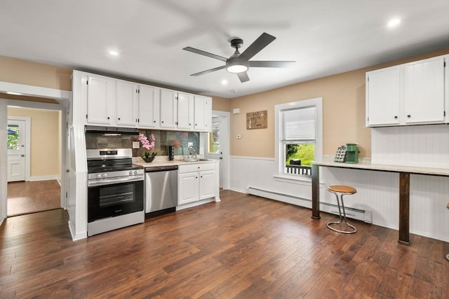 448 Washington St, Warren, MA 01083 - kitchen with appliances with stainless steel finishes, under cabinet range hood, baseboard heating, light countertops, and ceiling fan