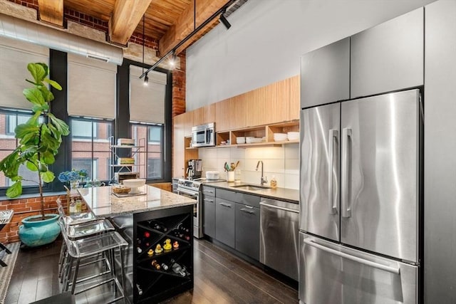 kitchen featuring dark wood finished floors, open shelves, a sink, decorative backsplash, and stainless steel appliances