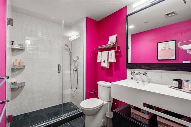 bathroom with vanity, toilet, visible vents, and a stall shower