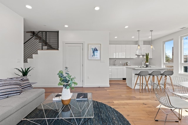 living room with sink and light hardwood / wood-style floors