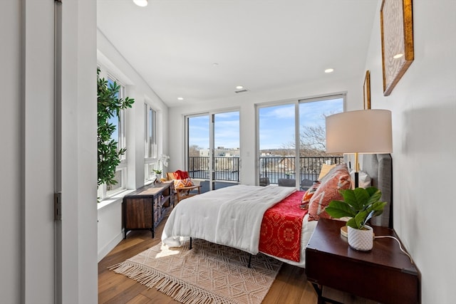 bedroom with wood-type flooring and access to exterior