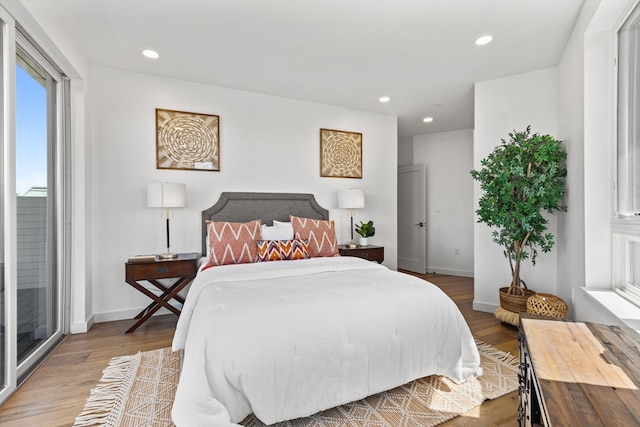 bedroom with access to exterior and wood-type flooring