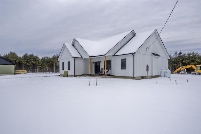 view of snow covered back of property