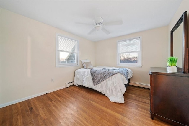 bedroom featuring a baseboard radiator, ceiling fan, and light hardwood / wood-style floors