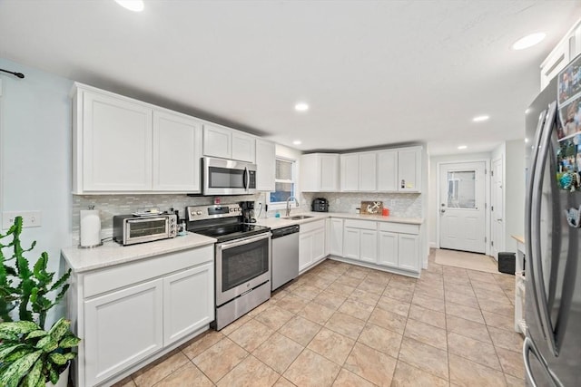 kitchen featuring tasteful backsplash, sink, stainless steel appliances, and white cabinets