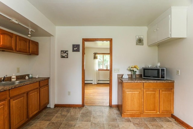 109 Bacon Rd, Springfield, MA 01119 - kitchen with stainless steel microwave, rail lighting, brown cabinets, dark countertops, and stone finish floors