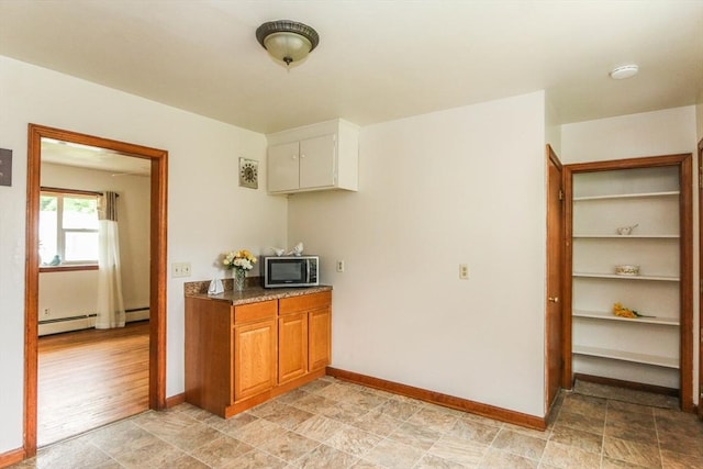 109 Bacon Rd, Springfield, MA 01119 - kitchen with stainless steel microwave, brown cabinetry, baseboard heating, and dark countertops