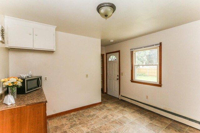 109 Bacon Rd, Springfield, MA 01119 - kitchen with baseboard heating, stainless steel microwave, white cabinetry, and stone finish floors