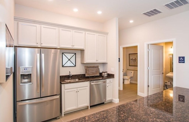 230 Martins Lndg Unit 310, North Reading, MA 01864 - kitchen with appliances with stainless steel finishes, white cabinets, light tile patterned floors, dark stone counters, and recessed lighting