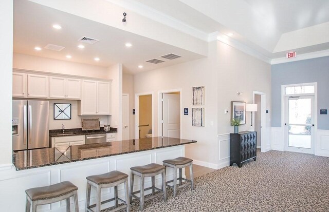 230 Martins Lndg Unit 310, North Reading, MA 01864 - kitchen featuring stainless steel appliances, a kitchen breakfast bar, white cabinetry, dark stone countertops, and recessed lighting