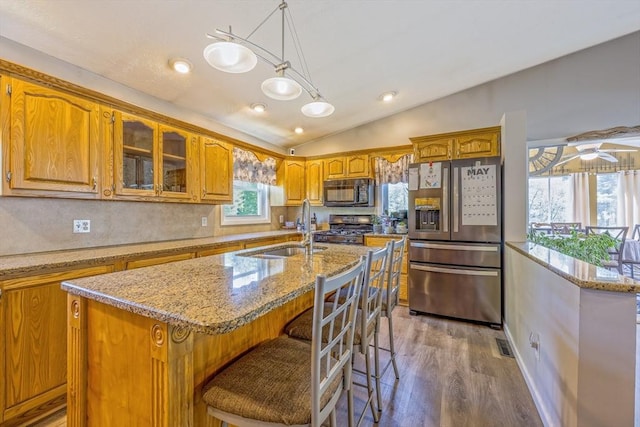 159 School St, Granby, MA 01033 - kitchen with stainless steel appliances, a sink, brown cabinetry, vaulted ceiling, and wood finished floors