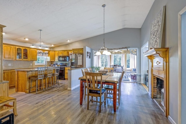 159 School St, Granby, MA 01033 - dining room featuring lofted ceiling, wood finished floors, a fireplace, a chandelier, and recessed lighting