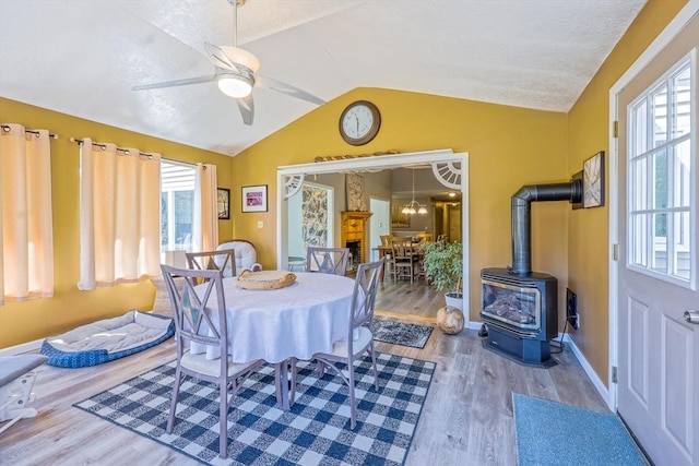 159 School St, Granby, MA 01033 - dining room featuring a wood stove, vaulted ceiling, wood finished floors, ceiling fan, and baseboards