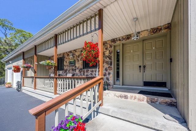 159 School St, Granby, MA 01033 - doorway to property featuring a porch, stone siding, and a garage