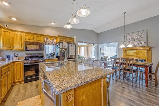 159 School St, Granby, MA 01033 - kitchen with black appliances, vaulted ceiling, a sink, light wood finished floors, and a kitchen island with sink