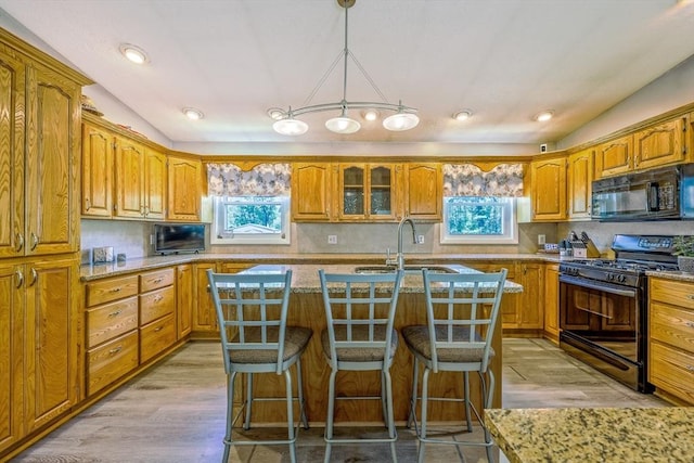 159 School St, Granby, MA 01033 - kitchen with black appliances, a center island with sink, healthy amount of natural light, brown cabinetry, and recessed lighting