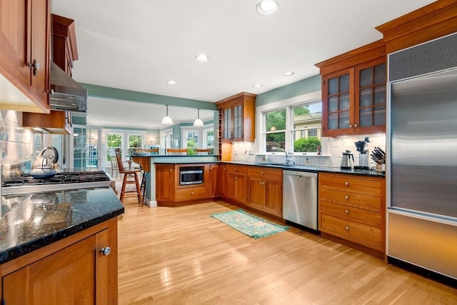 9 Palmer Rd, Marblehead, MA 01945 - kitchen with built in appliances, a peninsula, brown cabinets, light wood-style floors, and recessed lighting