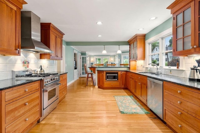 9 Palmer Rd, Marblehead, MA 01945 - kitchen with wall chimney range hood, stainless steel appliances, a sink, a peninsula, and light wood-type flooring