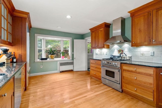 9 Palmer Rd, Marblehead, MA 01945 - kitchen with radiator, wall chimney exhaust hood, appliances with stainless steel finishes, decorative backsplash, and light wood-style flooring