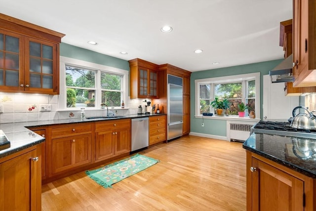 9 Palmer Rd, Marblehead, MA 01945 - kitchen featuring appliances with stainless steel finishes, radiator, brown cabinetry, light wood-style floors, and recessed lighting