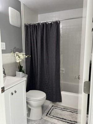 full bathroom with vanity, shower / tub combo with curtain, and toilet