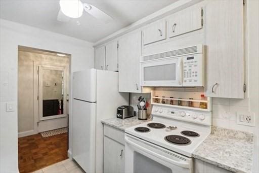 kitchen featuring ceiling fan, white appliances, and light stone counters