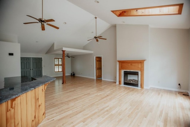 251 Butterworth Rd, Barre, MA 01005 - unfurnished living room featuring a ceiling fan, a fireplace with flush hearth, light wood-style flooring, and high vaulted ceiling