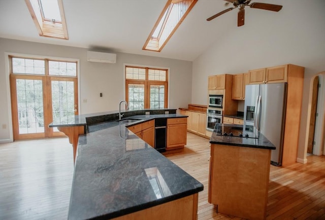 251 Butterworth Rd, Barre, MA 01005 - kitchen with appliances with stainless steel finishes, a large island with sink, high vaulted ceiling, light wood-style floors, and a skylight
