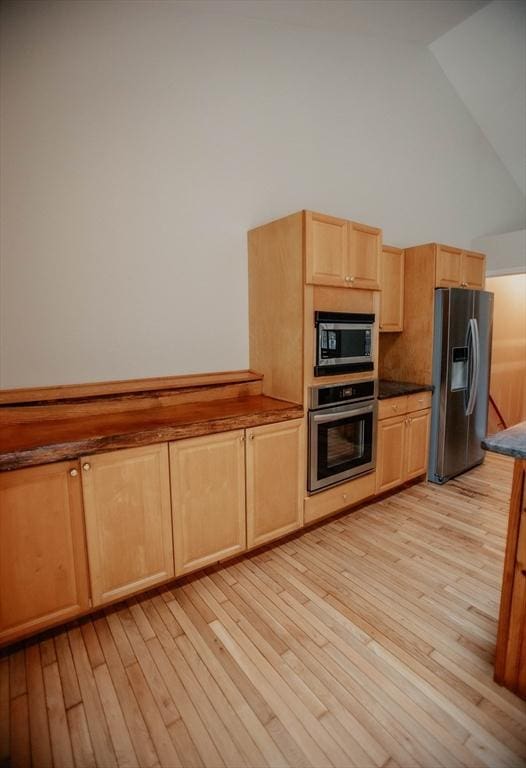 251 Butterworth Rd, Barre, MA 01005 - kitchen featuring appliances with stainless steel finishes, light brown cabinets, light wood-style floors, high vaulted ceiling, and dark countertops