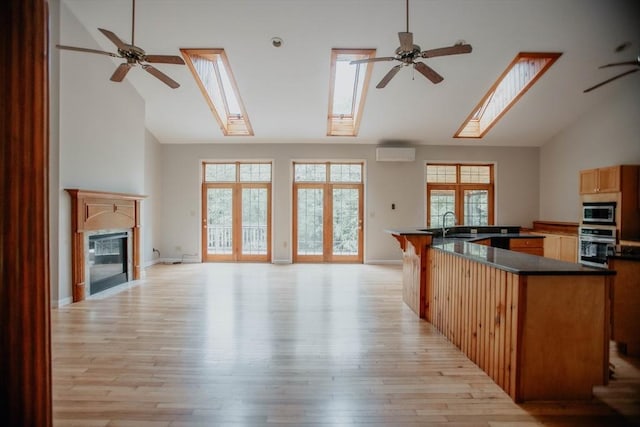251 Butterworth Rd, Barre, MA 01005 - kitchen with appliances with stainless steel finishes, a skylight, open floor plan, a wall mounted AC, and high vaulted ceiling