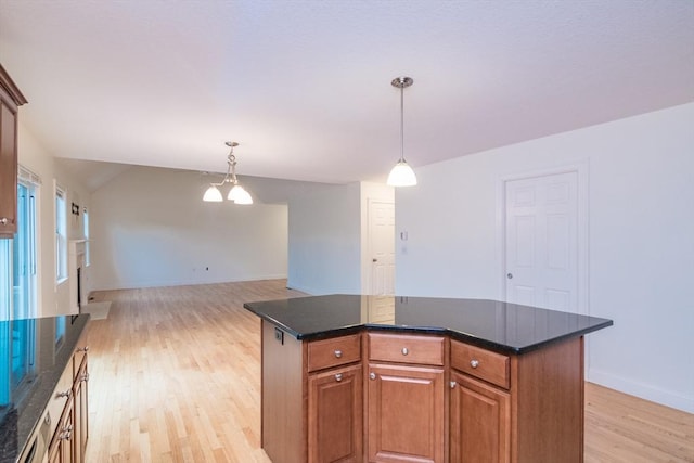 kitchen with light wood-style flooring, decorative light fixtures, a kitchen island, baseboards, and brown cabinetry