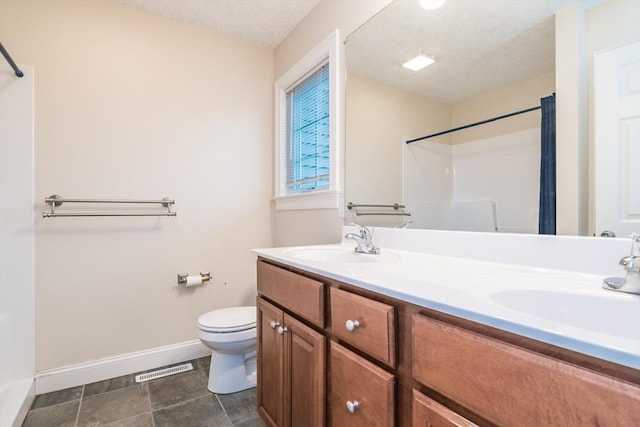 full bath featuring baseboards, toilet, curtained shower, double vanity, and a textured ceiling