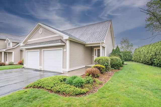 view of home's exterior with a shingled roof, asphalt driveway, a garage, and a lawn
