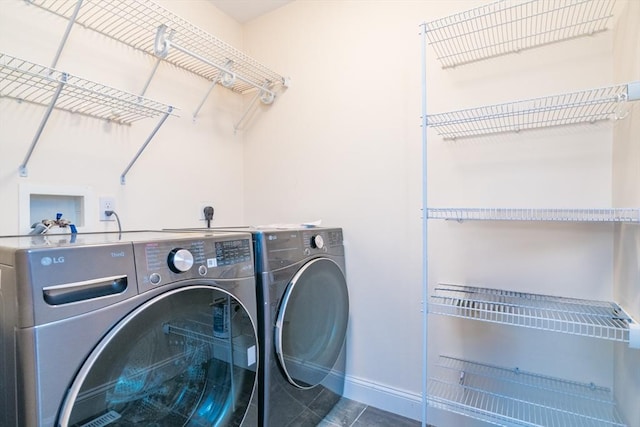 washroom featuring washing machine and dryer, baseboards, and tile patterned floors