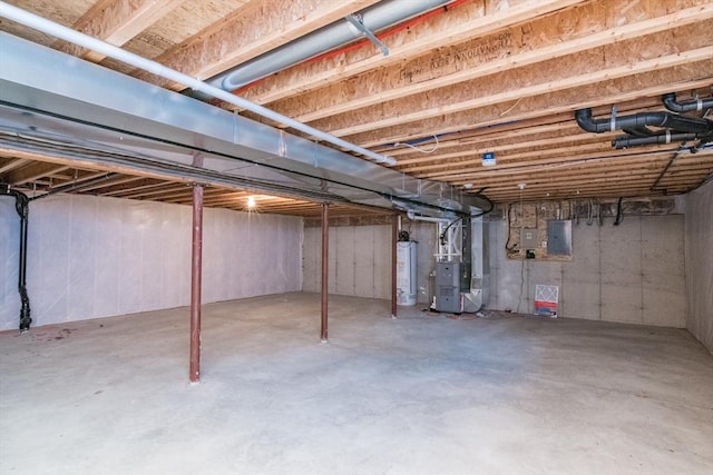 unfinished below grade area with heating unit, gas water heater, and electric panel