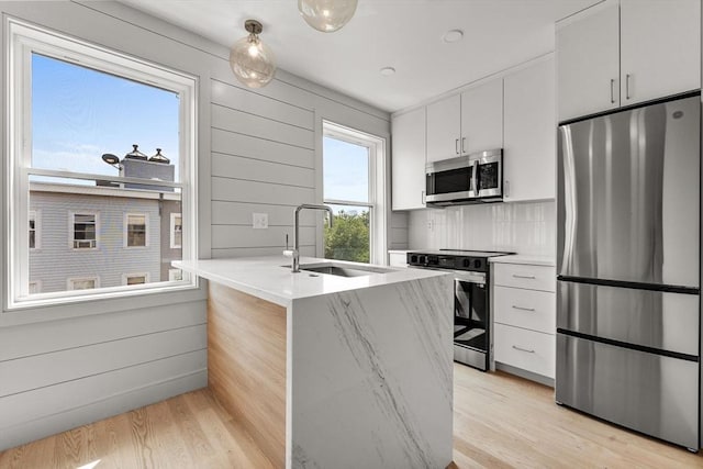 88 Maverick St Unit 3, Boston, MA 02128 - kitchen featuring stainless steel appliances, light wood-type flooring, white cabinets, and tasteful backsplash